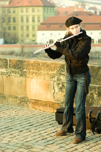 Girl busking with a flute in Prague